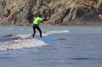 Séjour surf du service enfance, photo d'un jeune debout sur sa planche.